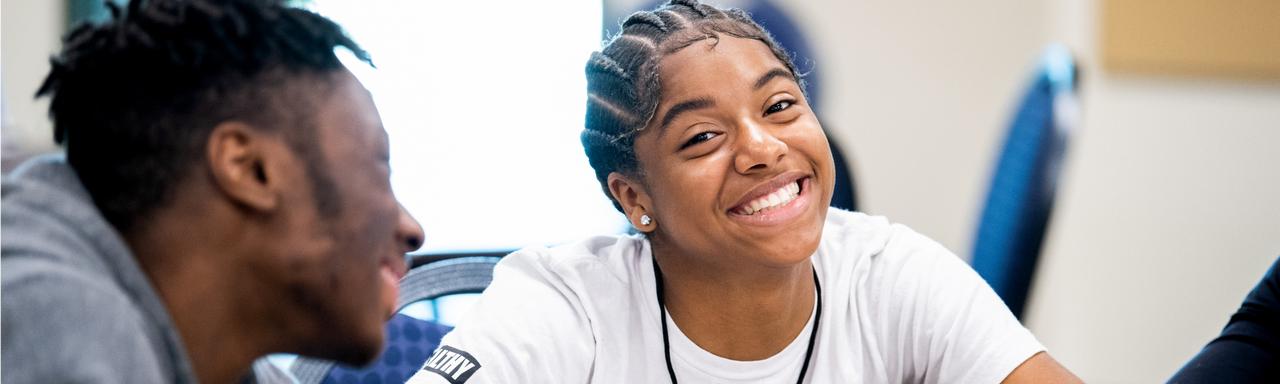 GVSU students smiling at a table